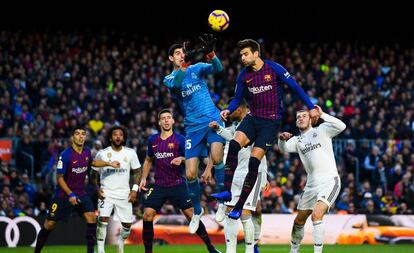 Courtois e Piqué disputam bola alta no primeiro clássico da temporada, no Camp Nou, quando o Barça venceu por 5 a 1.