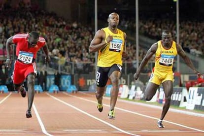 Asafa Powell, en medio, se impone a Marc Burns, de Trinidad y Tobago, y a Aziz Zakari, de Ghana.