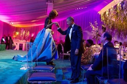 El expresidente Obama ayuda a bajar a su mujer después de que ella diera las gracias a los cocineros de la Casa Blanca durante la cena presidencial con François Hollande, expresidente de Francia.