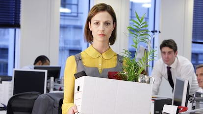 A woman leaving the office with her belongings.