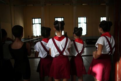 Estudiantes de la Escuela Nacional de Ballet observan una clase desde fuera.