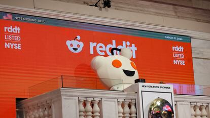 La mascota de Reddit toca la campana de apertura de la sesión en la Bolsa de Nueva York, este jueves, día del estreno de la empresa en Bolsa.