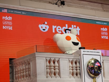 La mascota de Reddit toca la campana de apertura de la sesión en la Bolsa de Nueva York, este jueves, día del estreno de la empresa en Bolsa.