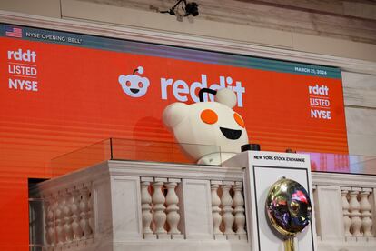 La mascota de Reddit toca la campana de apertura de la sesión en la Bolsa de Nueva York, este jueves, día del estreno de la empresa en Bolsa.