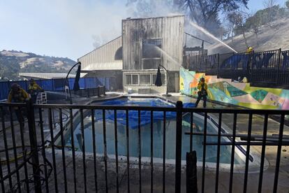 Na imagem, os bombeiros lançam água no edifício do Lafayette Tennis Club, em Lafayette, Califórnia, no domingo 27.