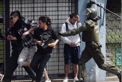 Un carabinero chileno carga contra varios estudiantes en Santiago.