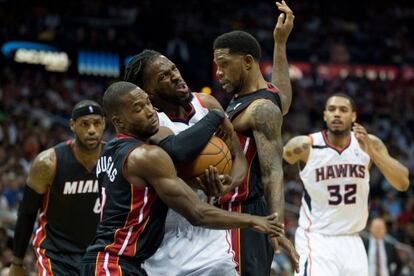 DeMarre Carroll, de Atlanta, lucha con Udonis Haslem y Toney Douglas