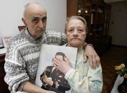 Los abuelos, en su casa con una foto de su nieto pequeño.