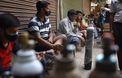 Varias personas esperan para rellenar sus botellas de oxígeno en una tienda de Nueva Delhi. 

