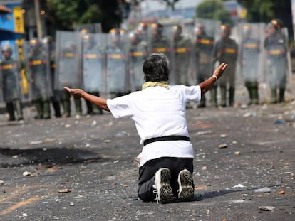 Un manifestante se arrodilla ante miembros de la Guardia Nacional, en Ureña