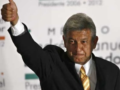Andrés Manuel López Obrador hace el signo de la victoria en la sede de su partido.