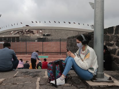 Una mujer hace uso de su teléfono celular afuera del Estadio Olímpico Universitario, en Ciudad de México.