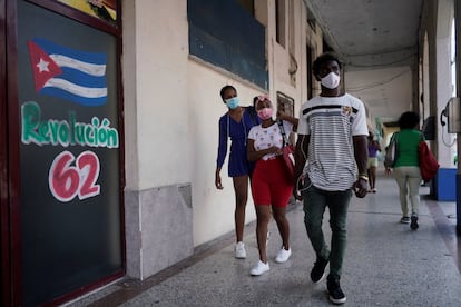 La gente pasa junto a un cuadro que hace referencia al 62 aniversario de la revolución cubana, en La Habana.