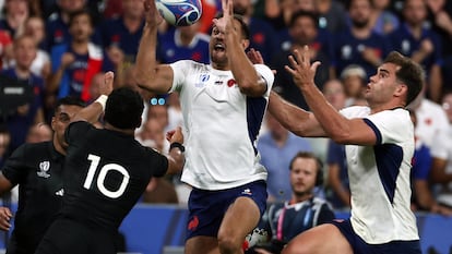 Melvyn Jaminet (C) y Damian Penaud (D) de Francia, disputan el balón frente a Richie Mo'unga de Nueva Zelanda.