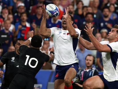 Melvyn Jaminet (C) y Damian Penaud (D) de Francia, disputan el balón frente a Richie Mo'unga de Nueva Zelanda.