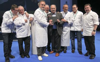 Los cocineros vascos Martín Berasategi (derecha), Hilario Arbelaitz (segundo dcha.), Karlos Arguiñano (tercero), Andoni Luis Aduriz (izquierda), Juan Mari Arzak (segundo izqda.), Ramón Roteta (tercero) y Pedro Subijana (cuarto) posan con Luis Irizar (cuarto dcha.) en el homenaje que le ha tributado hoy el Congreso San Sebastián Gastronomika.