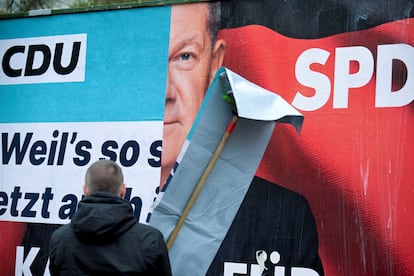 Un retrato de Olaf Scholz del Partido Socialdemcrata (SPD) es pegado sobre carteles electorales para las prximas elecciones estatales de Hamburgo. 