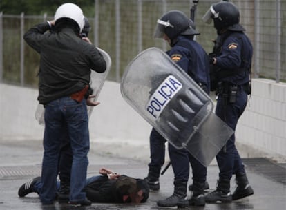 Agentes de los antidisturbios mantienen reducido en el suelo a uno de los detenidos por los altercados en Madrid.