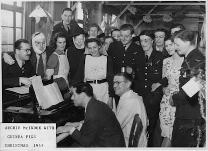 El doctor Archibald McIndoe, al piano, rodeado de sus pacientes en del 'Guinea Pigs Club'.