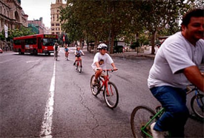 Una familia pasea en bicicleta por la plaza del Ayuntamiento de Valencia.
