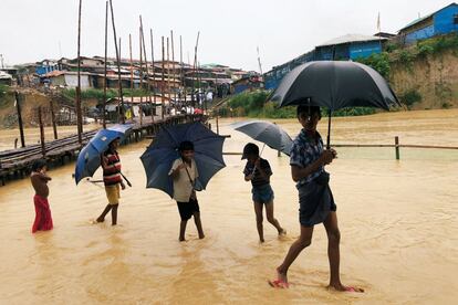 Niños rohingyás caminan entre el agua que inunda el campamento de Kutupalong, en Cox's Bazar (Bangladés).