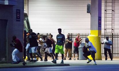 Assistents a la manifestació contra la violència policial corren durant el tiroteig.