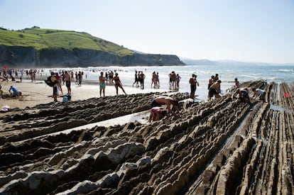 La bajamar permite tocar con la mano los dientes de sierra que forman la rasa mareal en la playa de Itzurun, en Zumaia (Guipúzcoa).