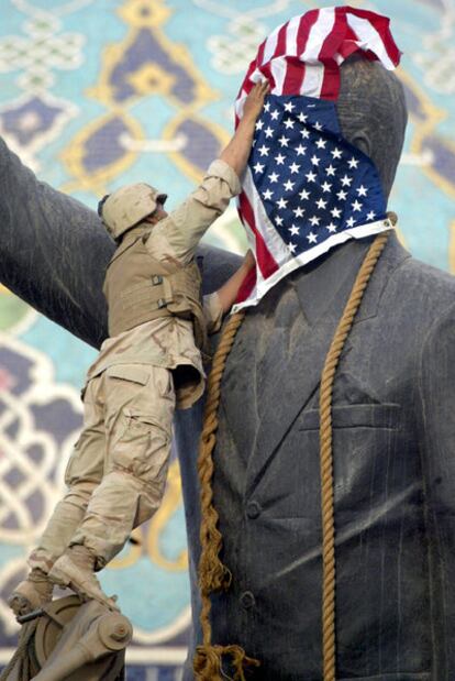Un soldado coloca la bandera de EE UU sobre la estatua de Sadam Husein en Bagdad, el 9 de abril de 2003.