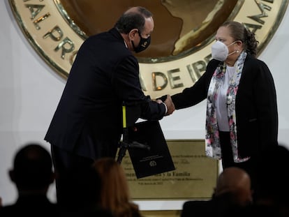 Consuelo Porras estrecha la mano del presidente de Guatemala, Alejandro Giammattei, después de ser renovada como fiscal general.