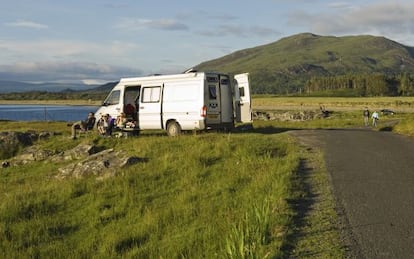 Una familia acampada con su autocaravana junto a la costa de Loch na Keal, en la isla de Mull, Escocia (Reino Unido).