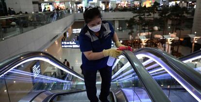 Trabajadores desinfectan unas escaleras mecánicas en el aeropuerto de Incheon (Corea del Sur). 