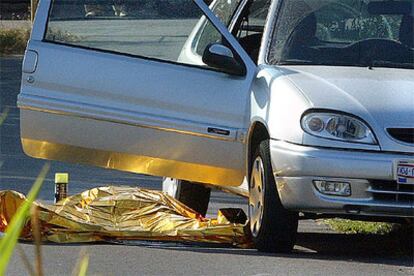 El cadáver de Consol Galcerán, de 55 años, cubierto por una manta térmica, yace en el suelo junto a su coche.
