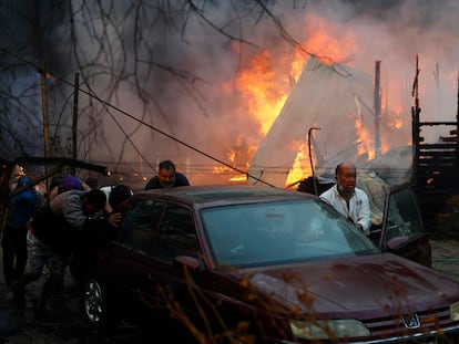 Residentes de Villa Alemana, en Valparaíso (Chile), empujan un automóvil para escapar de los incendios en la región, el pasado 2 de febrero.