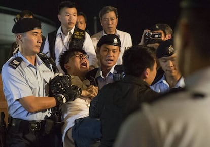 La policía detiene al joven activista Joshua Wong (c), conocido líder de la "Revolución de los Paraguas", durante una protesta en favor del sufragio universal y de la liberación del disidente chino Liu Xiaobo, en Hong Kong, este miércoles