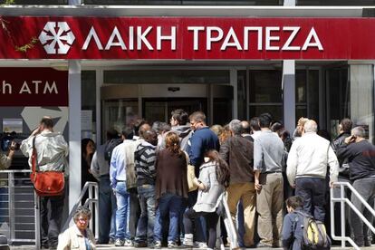 Gente ante una sucursal del Laiki esperan a que el banco reabra sus puertas, este jueves en Nicosia.