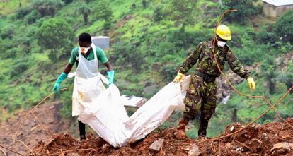 Un voluntario y un soldado transportan el cuerpo de una víctima de las inundaciones del pasado 19 de agosto en Freetown, capital de Sierra Leona. Hay más de 400 muertos y más de 600 heridos.
