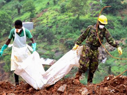 Un voluntario y un soldado transportan el cuerpo de una v&iacute;ctima de las inundaciones del pasado 19 de agosto en Freetown, capital de Sierra Leona. Hay m&aacute;s de 400 muertos y m&aacute;s de 600 heridos.