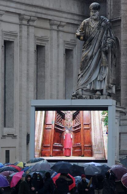 Cientos de personas observan la pantalla gigante instalada en la plaza de San Pedro, en Ciudad del Vaticano, en el momento en que se cierran las puertas de la capilla Sixtina para comenzar la votación.