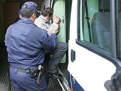 Uno de los asaltantes, ayer, al ser introducido en una furgoneta policial.