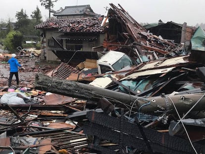 Un hombre camina por los escombros de varias casas desplomadas por el tifón Hagibis en Ichihara, al este de Tokio.