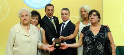 El diputado general, José Luis Bilbao, y el 'lehendakari' Iñigo Urkullu posan con la distinción de Ilustre de Bizkaia junto a familiares de las víctimas.