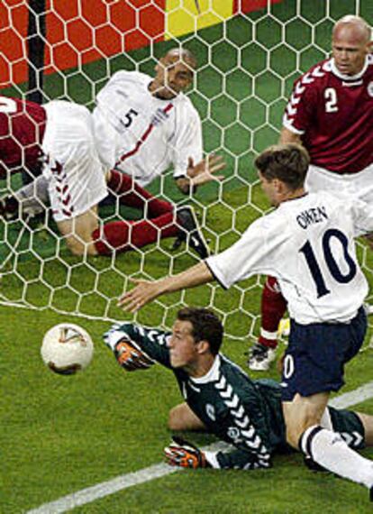 El portero danés Sorensen, ante Owen, en el proceso de introducir en su portería el primer gol inglés.
