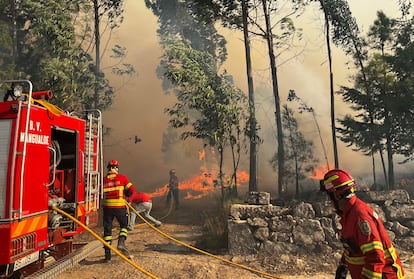 Bomberos y voluntarios intentan apagar el incendio que rodea  la localidad portuguesa de Mesquitela, este martes. 
