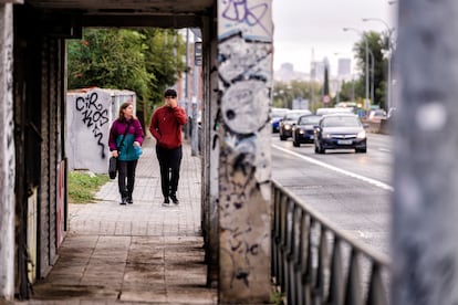 Dos personas pasean por una acera estrecha y en mal estado en el paseo de Extremadura de Madrid, junto a seis carriles de coches. 