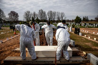 Un grupo de sepultureros bajan el ataúd de una víctima de covid-19 para enterrarla en el cementerio de la Asociación Hebrea de Entierros Libres para judíos empobrecidos, en Staten Island, Nueva York, el 7 de abril de 2020.