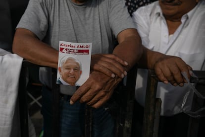 Un simpatizante del presidente sostiene un tríptico con la imagen de López Obrador.