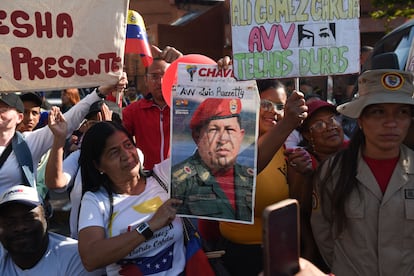 A woman carries a portrait of late Venezuelan President Hugo Chavez during a caravan in Caracas on March 15, 2023.