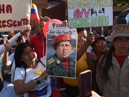 A woman carries a portrait of late Venezuelan President Hugo Chavez during a caravan in Caracas on March 15, 2023.