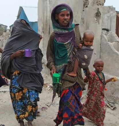 Una mujer somalí se dirige, acompañada de sus hijos, a uno de los campos de desplazados de Mogadiscio.