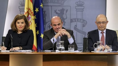 La vicepresidenta del Gobierno, Soraya Sáenz de Santamaría, junto a los ministros de Economía, Luis de Guindos; y de Hacienda, Cristóbal Montoro, durante la rueda de prensa tras la reunión semanal del Consejo de Ministros.